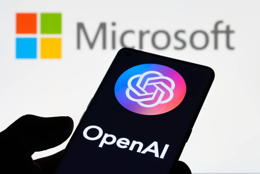 Logo OPENAI widoczne na ekranie smartfona i laptopa z logo MICROSOFT w tle