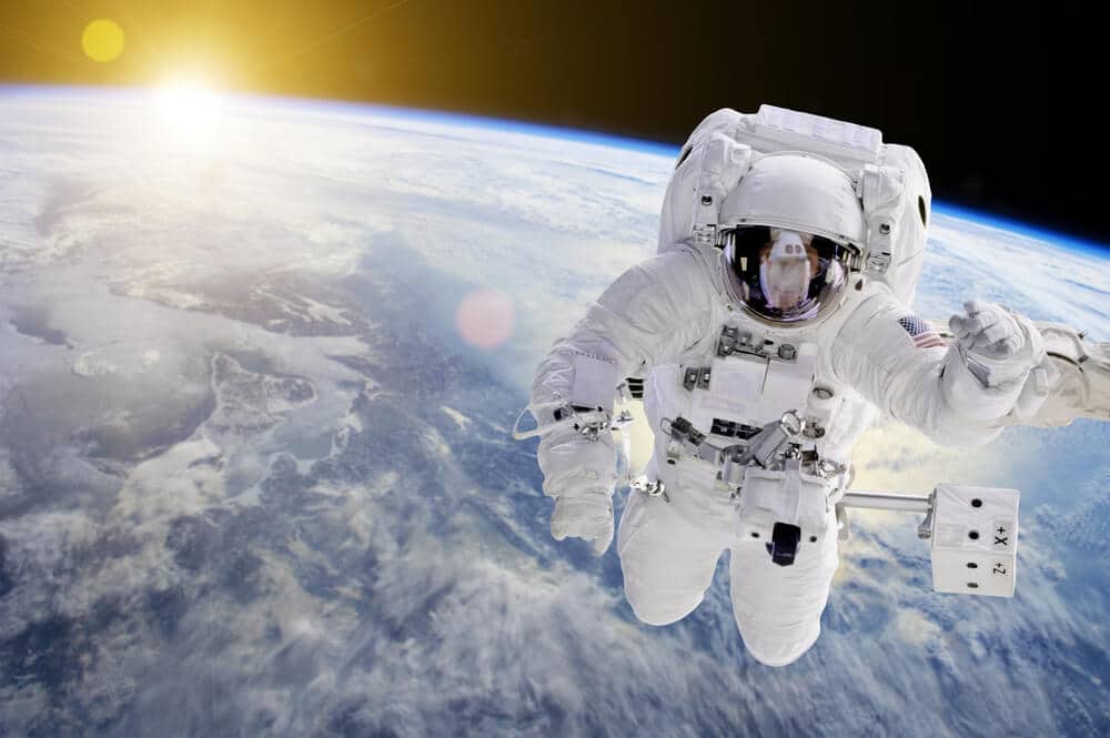 Misje NASA - Astronauta w kosmosie, w tle nasza Ziemia i Słońce – elementy tego obrazu dostarczone przez NASA