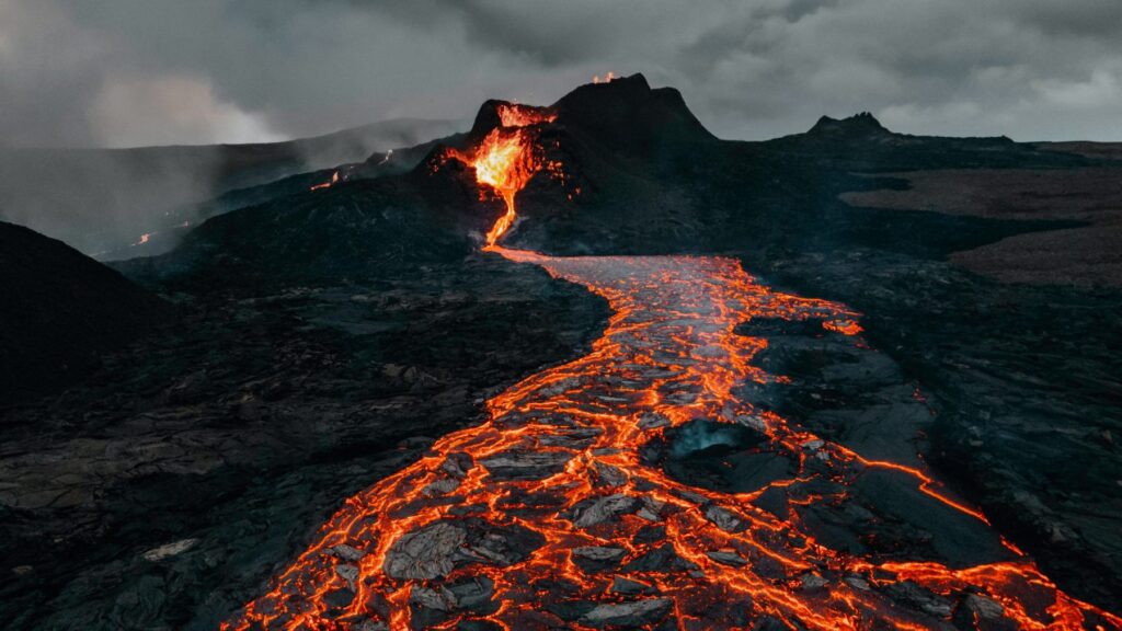 Erupcje wulkaniczne – największe wybuchy XXI wieku, mapa aktywnych wulkanów i globalne zagrożenia Erupcje wulkaniczne – potok lawy spływający ze stożka aktywnego wulkanu podczas erupcji