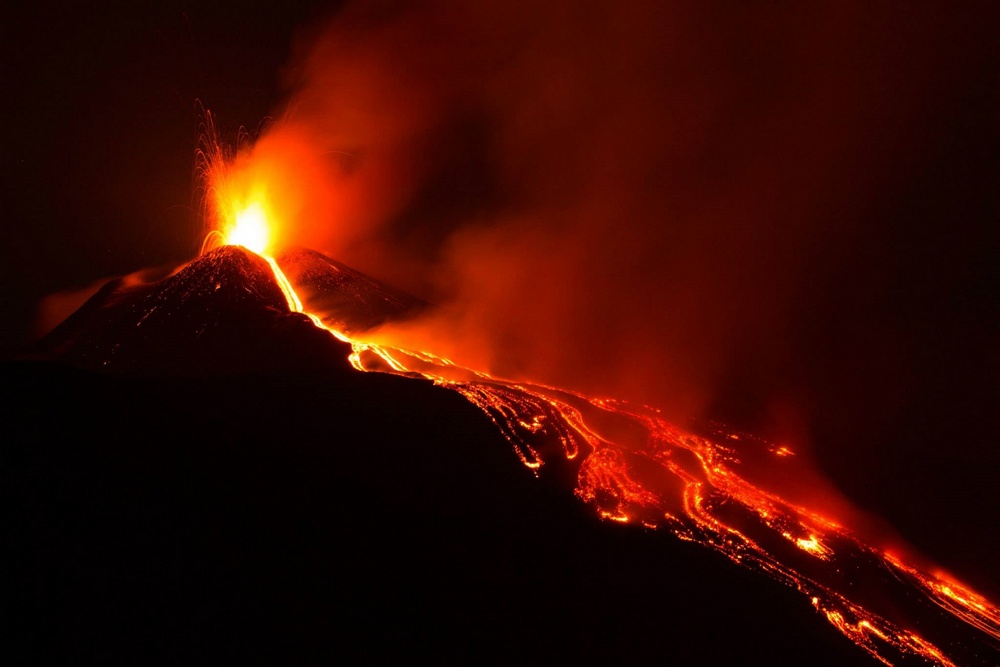 Wybuch wulkanu Etna z długim strumieniem lawy widzianym nocą